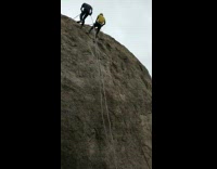 Two Rock Climbers Go Down Cliff Rock