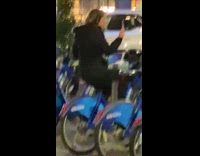 Woman pedaling in reverse on parked bike