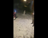 Guy yellow coat snow cameraman kneel dance