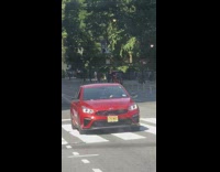 Man rides tricycle by pushing on white street barriers