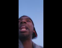 Guy rides down long road on blue bike, red earphones, Jamaican style