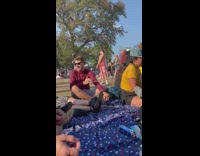 Woman pink jumpsuit with pink sunglasses poses at the music festival