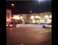 Two cars do donuts in parking lot