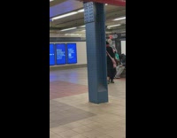 Husband and wife slow dancing next to guy singing in subway