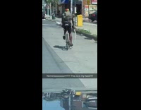 Black shorts guy holds snake rides bicycle 
