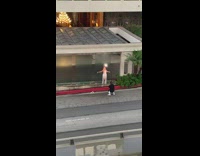 Woman in white dress poses in front of the glass waterfalls