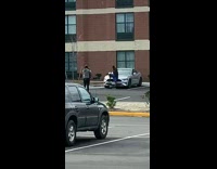 Man sits on silver car for pictures