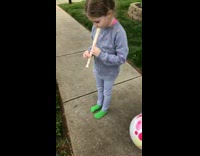 Little girl plays the flute for dead lizard funeral on the grass