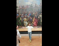 Collab IITW - Man white shirt yellow shoes Poses in Museum with Humongous Artwork as Background