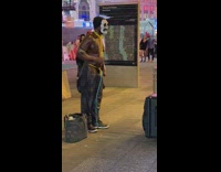 Guy wearing skeleton costume mask exercises with resistance band 