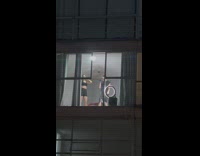Man and woman film TikTok near apartment window 