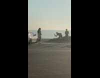 Guy long hair shirt beside car beach