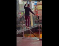 Guy tries to walk on stair rails 