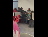 School couple in same side booth flirting and play fighting