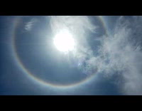 Rainbow halo ring around sun blue sky