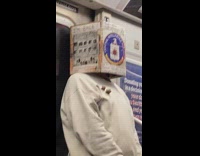 Man covers head with box inside train