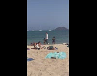 Woman in violet bikini poses at the beach shore