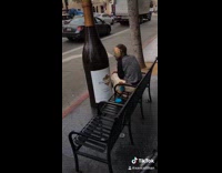Man carries big giant chardonnay wine bottle then puts peanut butter on his face on bench