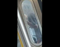Man dancing in between two subway cars
