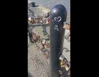 Married couple names padlocks on railings bay