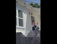 Neighbor holds up baby at frat party