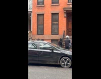 Group wears blindfold films video on sidewalk