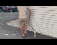 Guy rides razor scooter into white all and falls on the ground driveway