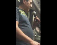 Guy sings karaoke on speaker machine with coin cup that says touch me feel me love me