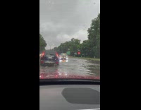 White car stuck in flood on highway