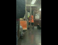 Orange shirt guy dances metal pole subway