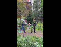 Two men pull baby mannequin move park