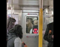 Group of women standing in between subway car connector