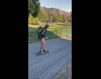 Girl riding skateboard jumps off onto grass 
