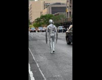 Guy in Terminator 2 costume walks down street 