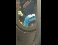 Toddler Kid With Cookie Monster Hat Stares Through Subway Doors