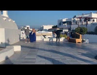 Woman in blue dress poses while man lifts her dress train