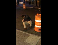 Guy kicks yellow cone and ends up falling on his back