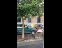 Shirtless man drive green car on sidewalk