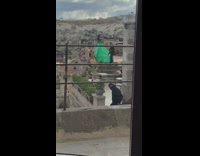 Woman in green dress poses at the hotel terrace