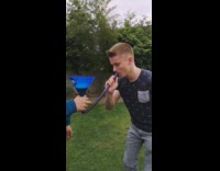 Guy drinks out of beer bong and get beer spilt on his face