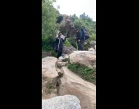Two guys struggle to climb down mountain 