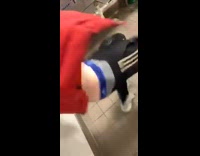 Guy orange red jacket slides on wet floor and slips then falls