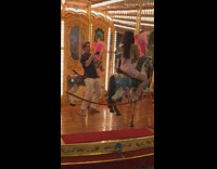 Woman pink dress rides horse carousel for photoshoot