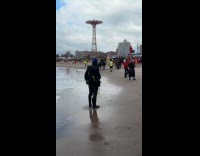 Photographers wait on the cloudy beach shore