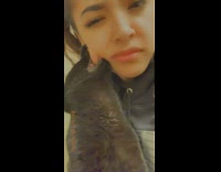 Black cat bites and holds onto cheek