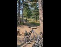 Guy on a bike attempts a jump off a wooden ramp in the mountains 