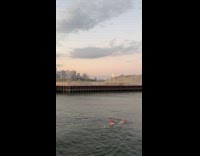 Man swim on river with small red buoy
