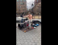 Shirtless man sing play drums at park