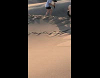 Photographer holds camera picture sand dunes