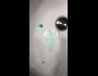 Girl spits toothpaste sink laughs grey countertop 